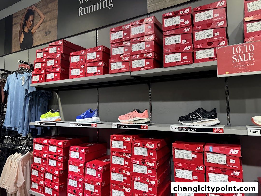 New Balance store interior with shoes, apparel, and stacked shoe boxes.