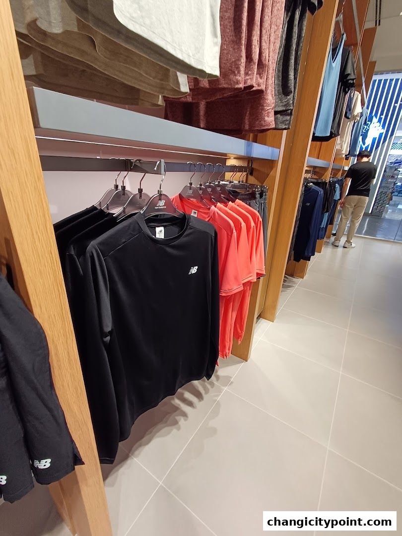 Interior view of a New Balance store showcasing athletic apparel on display racks.