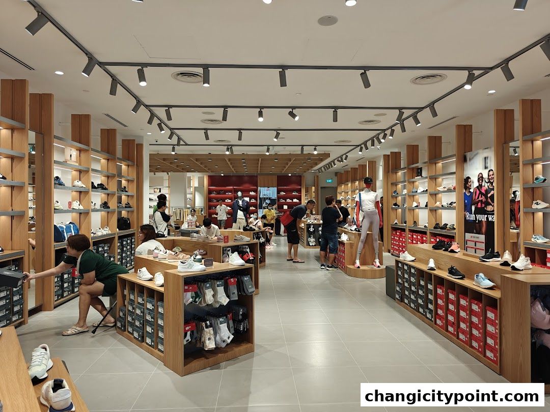 Interior of a New Balance store showcasing shoes, apparel, and accessories on shelves and displays.