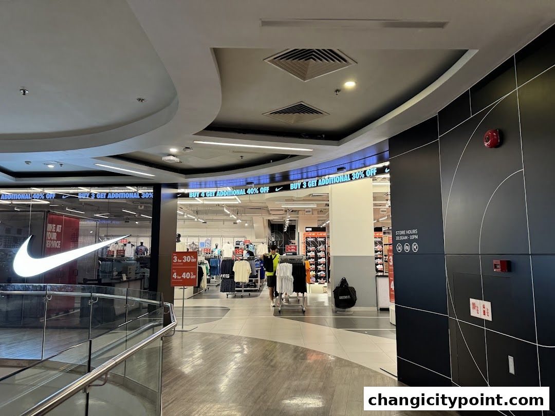 Entrance to a Nike Factory Store with prominent signage and sale offers.
