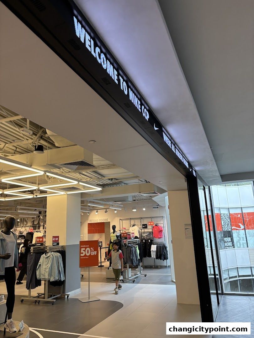 Interior view of a Nike Factory Store with clothing displays and a welcome sign.
