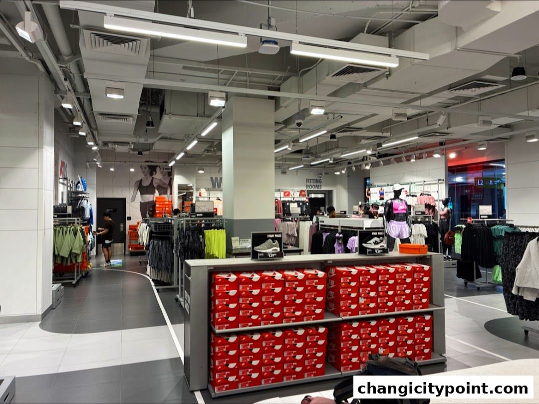 Interior view of a Nike Factory Store with apparel, shoes, and stacked shoe boxes.