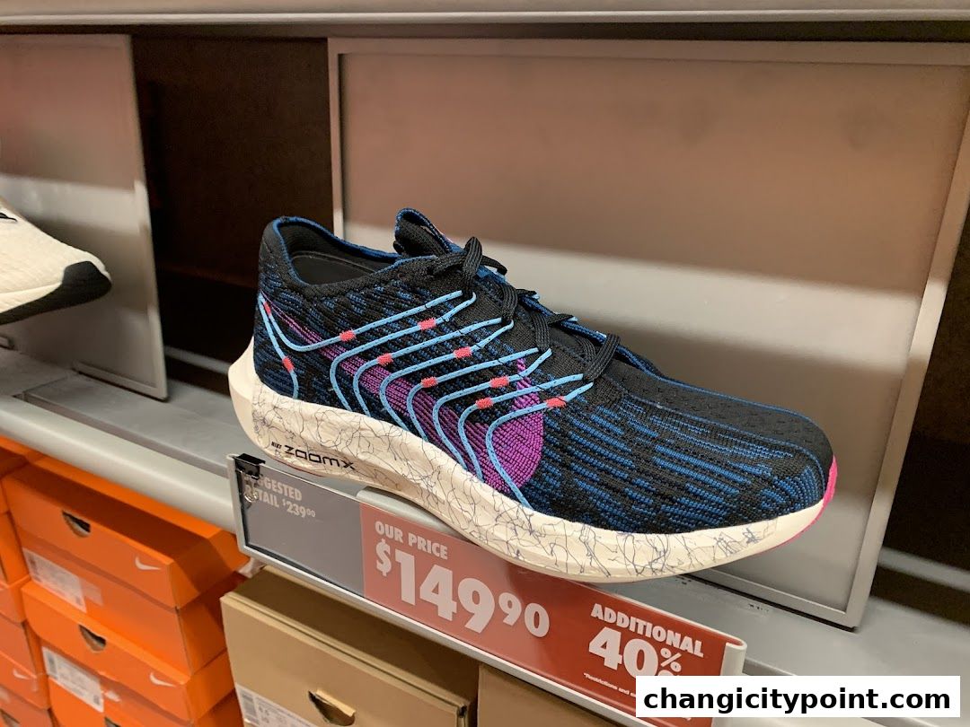 A close-up of a Nike running shoe with a black, blue, and pink design on display.