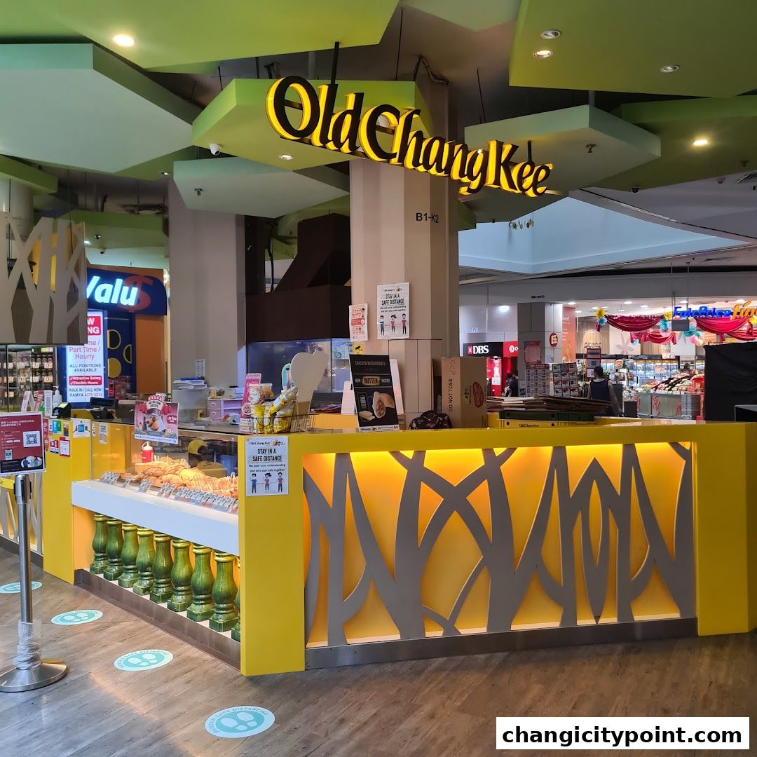 The Old Chang Kee shop front with a bright yellow counter displaying food items.