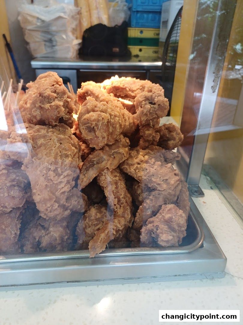 A close-up shot of a tray filled with crispy, golden-brown fried chicken pieces.