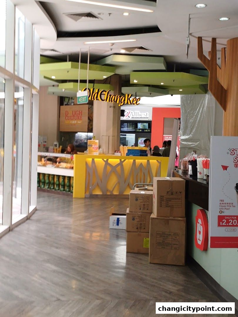 The entrance of Old Chang Kee shop with colorful decor and stacked boxes.