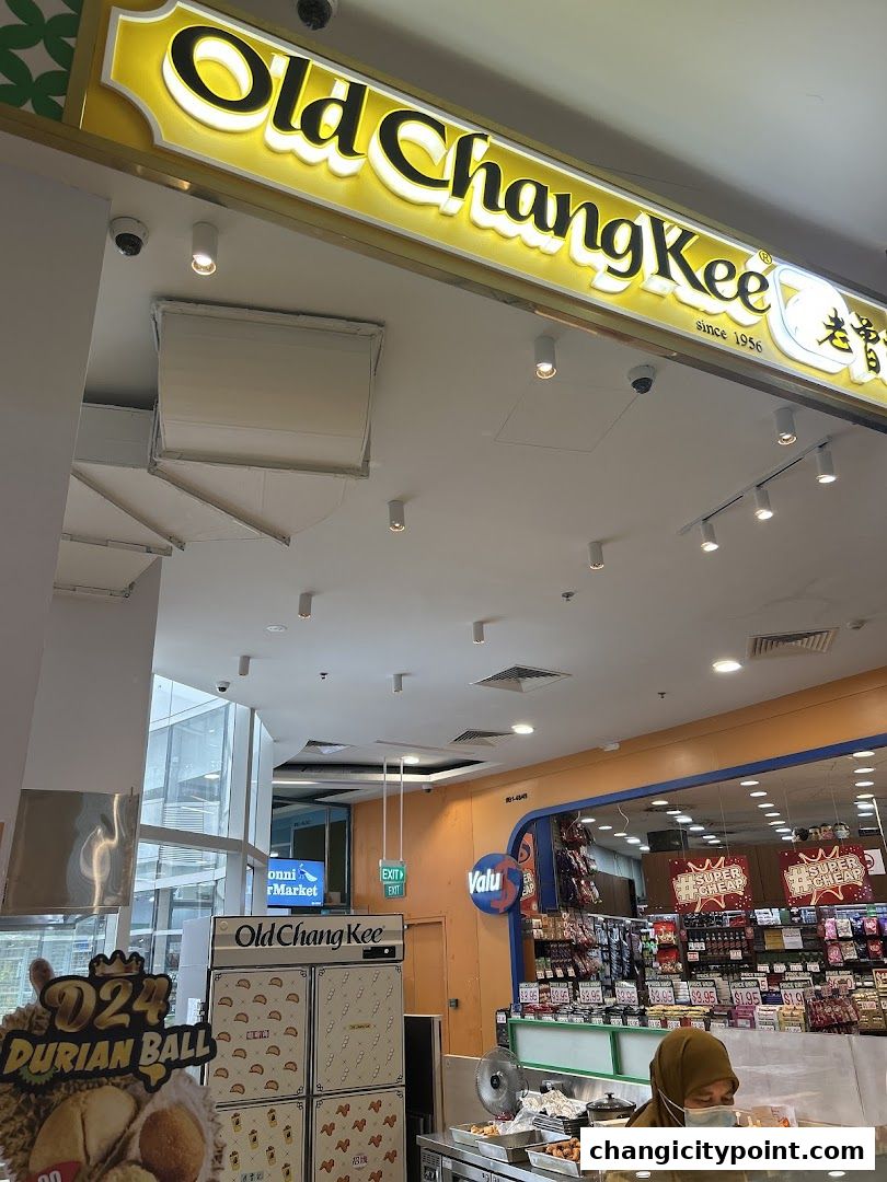 The exterior of an Old Chang Kee shop with its prominent signage and display of food items.
