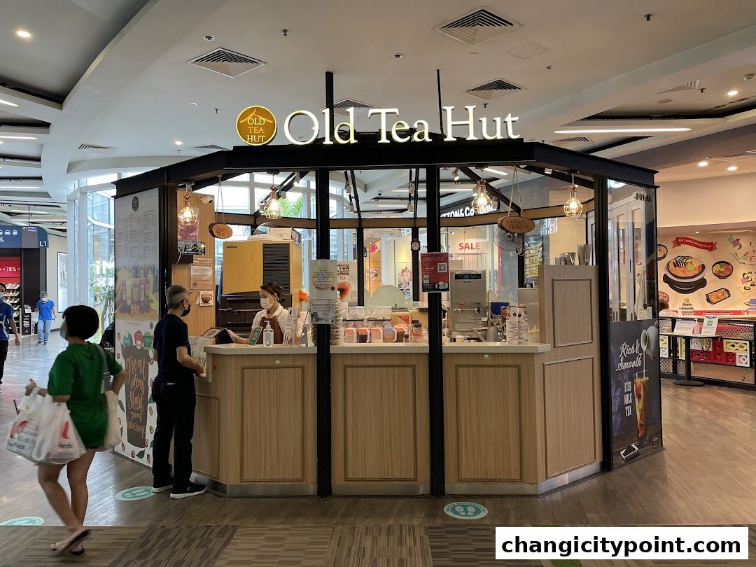 Old Tea Hut shop front with staff serving customers and a menu board visible.