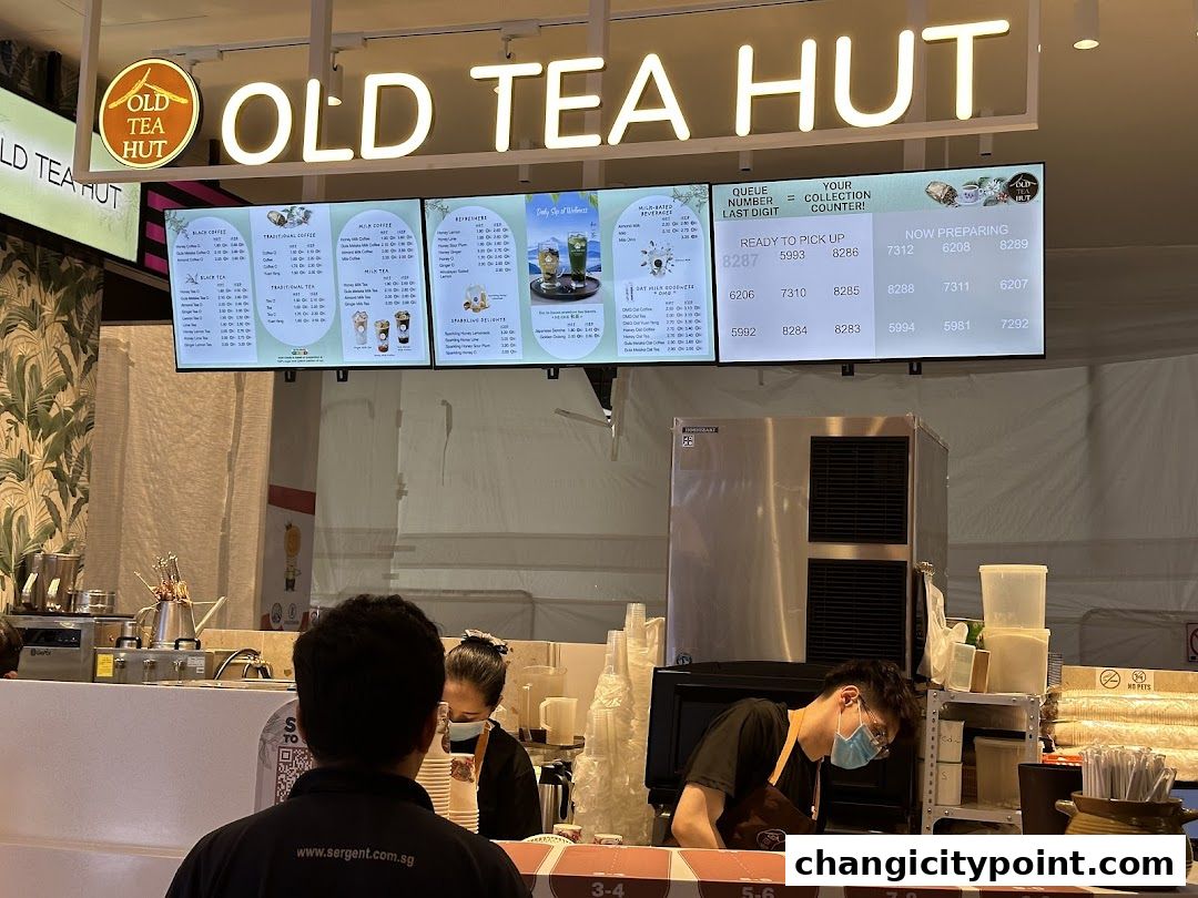 A digital menu board displays various tea and coffee options at Old Tea Hut.