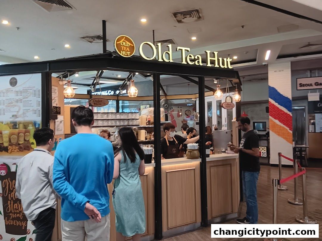 Customers ordering at the Old Tea Hut counter in a mall.