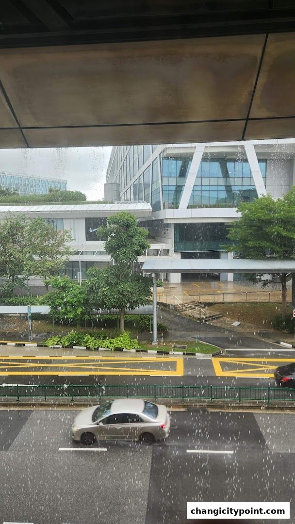 A view of a modern building with a Nike store during a rain shower.