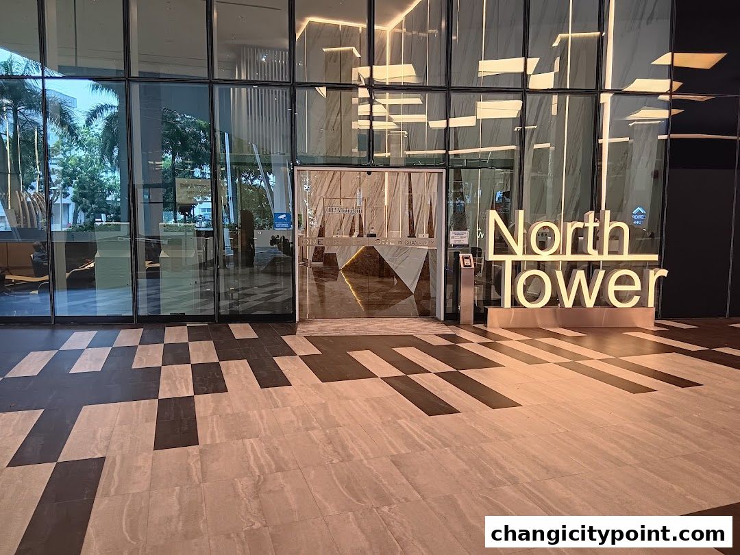 Modern building entrance with large glass facade and illuminated 'North Tower' sign.