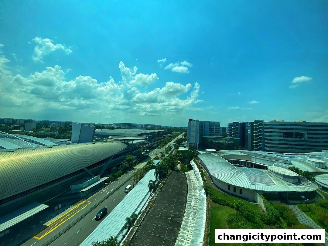 Aerial view of ONEChangi City complex with modern architecture under a blue sky.
