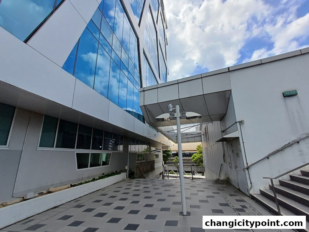 Modern building exterior with reflective glass windows and an outdoor walkway.