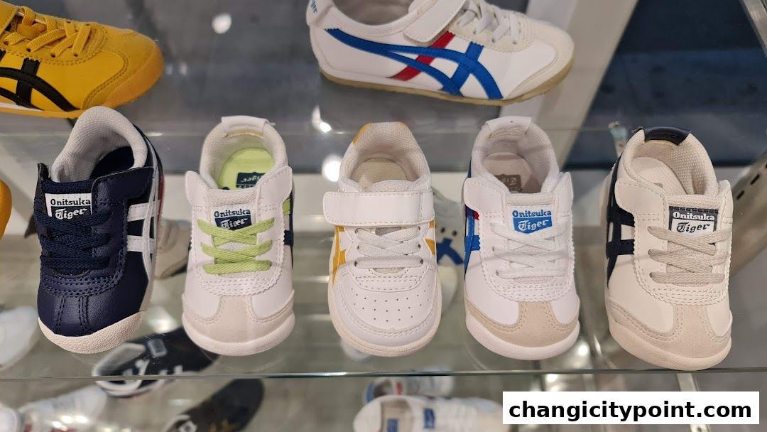 A display of various Onitsuka Tiger baby shoes in different colors and styles.