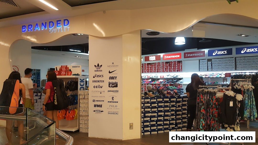 Entrance of a branded outlet store selling shoes and apparel with various brand logos displayed.