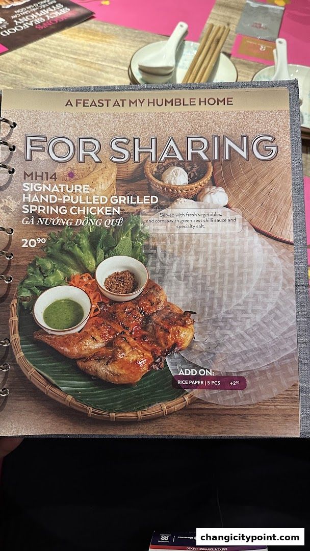 A menu page showcasing a signature grilled spring chicken dish with fresh vegetables and dipping sauces.