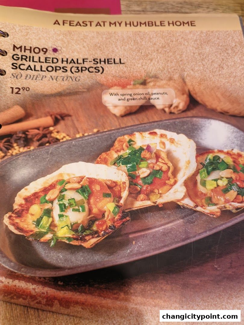 A menu item featuring grilled half-shell scallops with a savory topping.