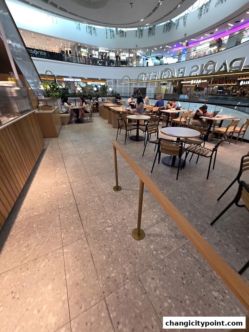 Interior view of Paris Baguette cafe with seating areas and customers.