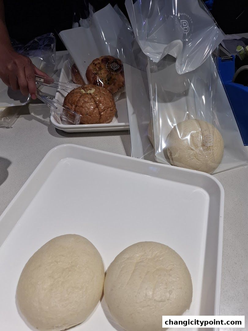 Freshly baked bread and pastries are being prepared for customers.