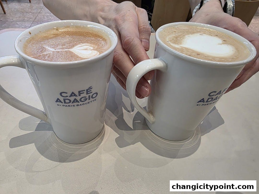 Two mugs of coffee with latte art, branded by Paris Baguette.