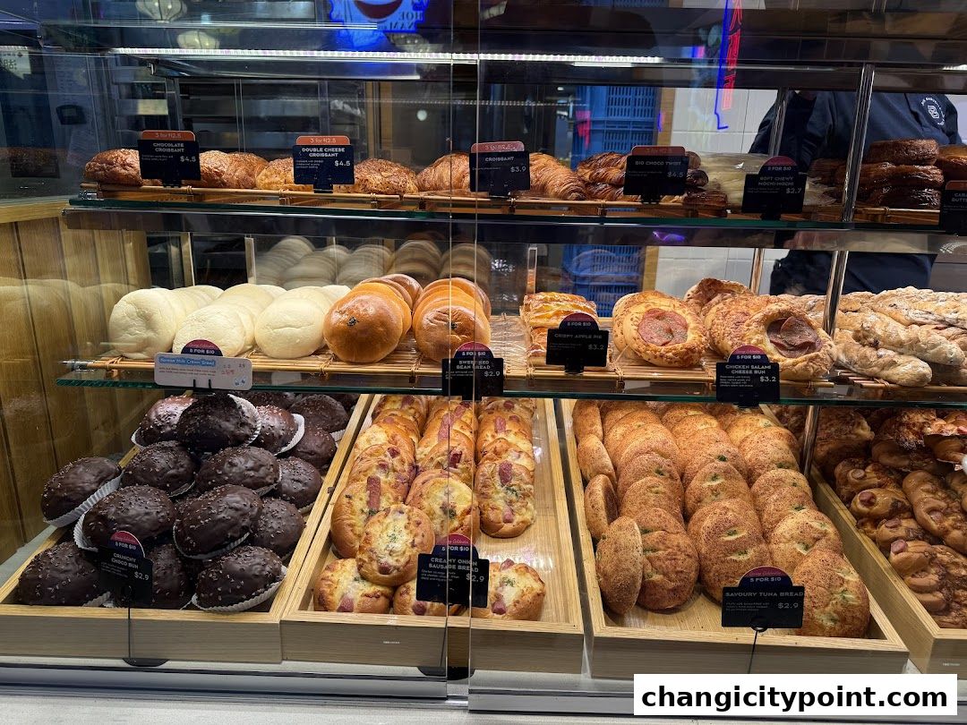A display case filled with a variety of freshly baked pastries, breads, and desserts.