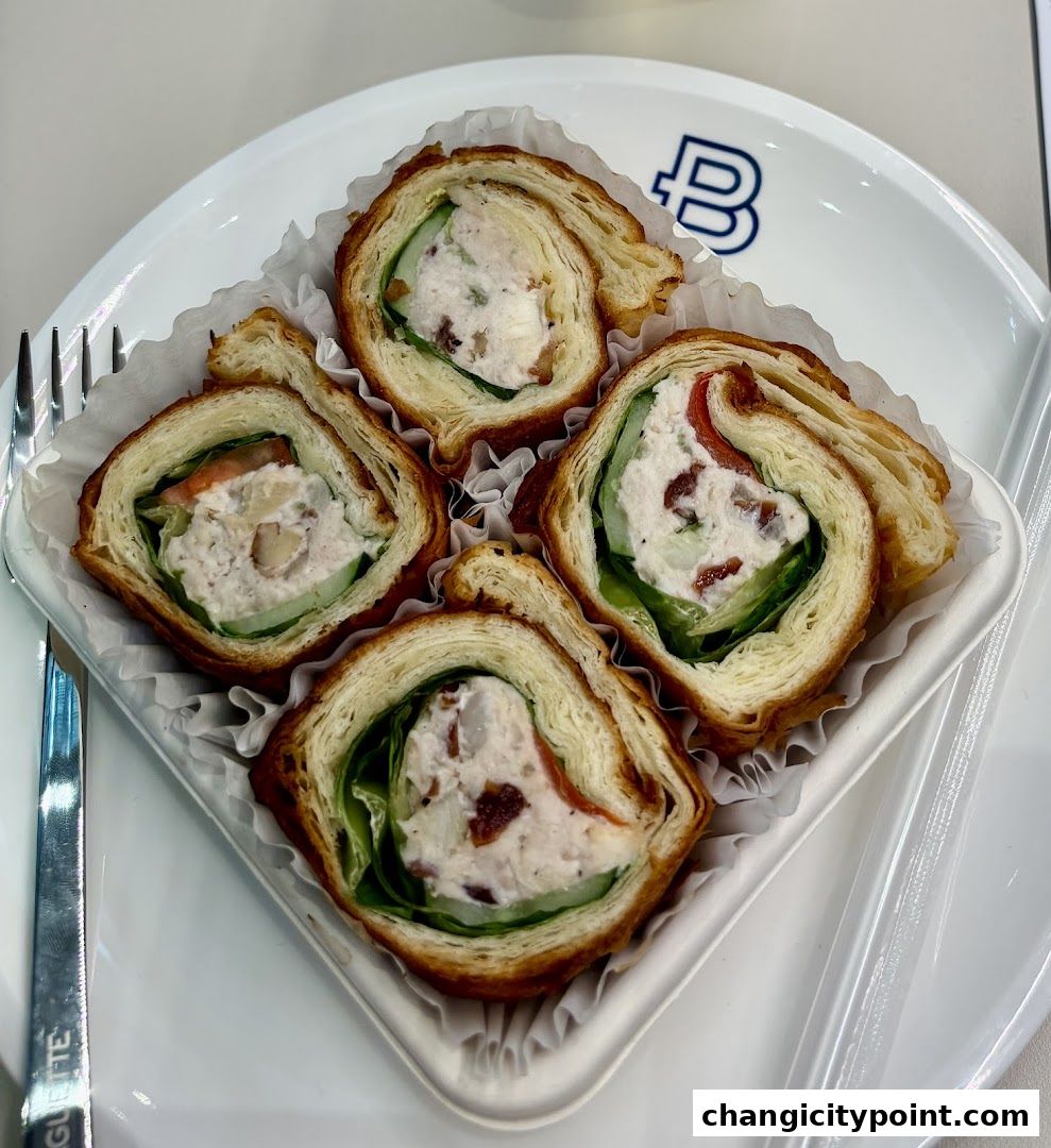 Four savory croissant rolls filled with chicken salad, cucumber, and greens.