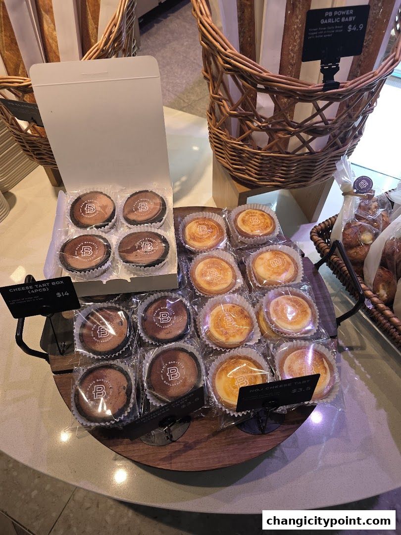 Paris Baguette display of cheese tarts and bread in baskets.