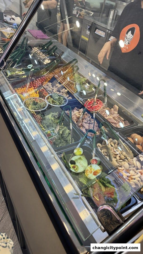 A display case filled with various fresh ingredients for pasta or salads.