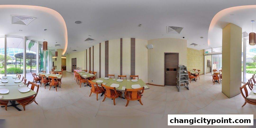 Interior view of a restaurant with tables set for dining and large windows.