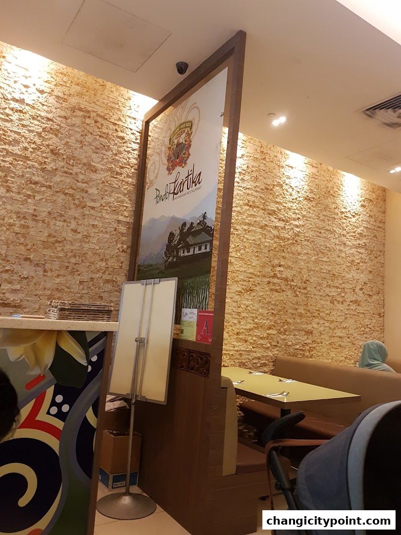 Interior of Pondok Kartika Indonesian Restaurant with a large sign and seating area.
