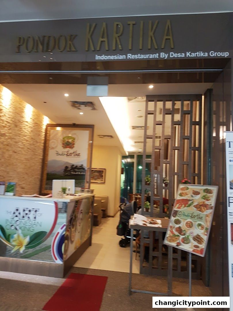The entrance of Pondok Kartika, an Indonesian restaurant, with a menu stand outside.