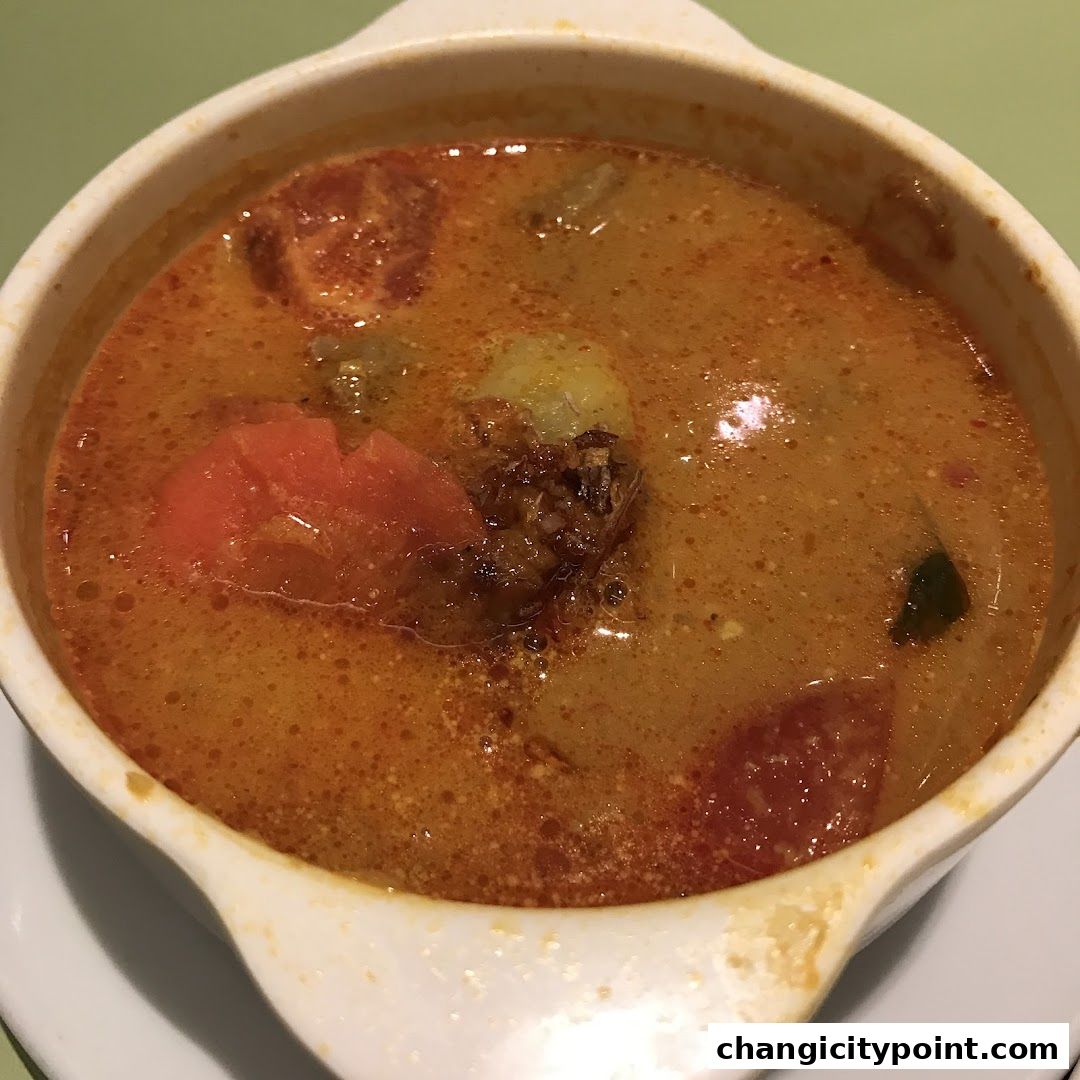 A close-up shot of a hearty bowl of curry with chunks of meat and vegetables.