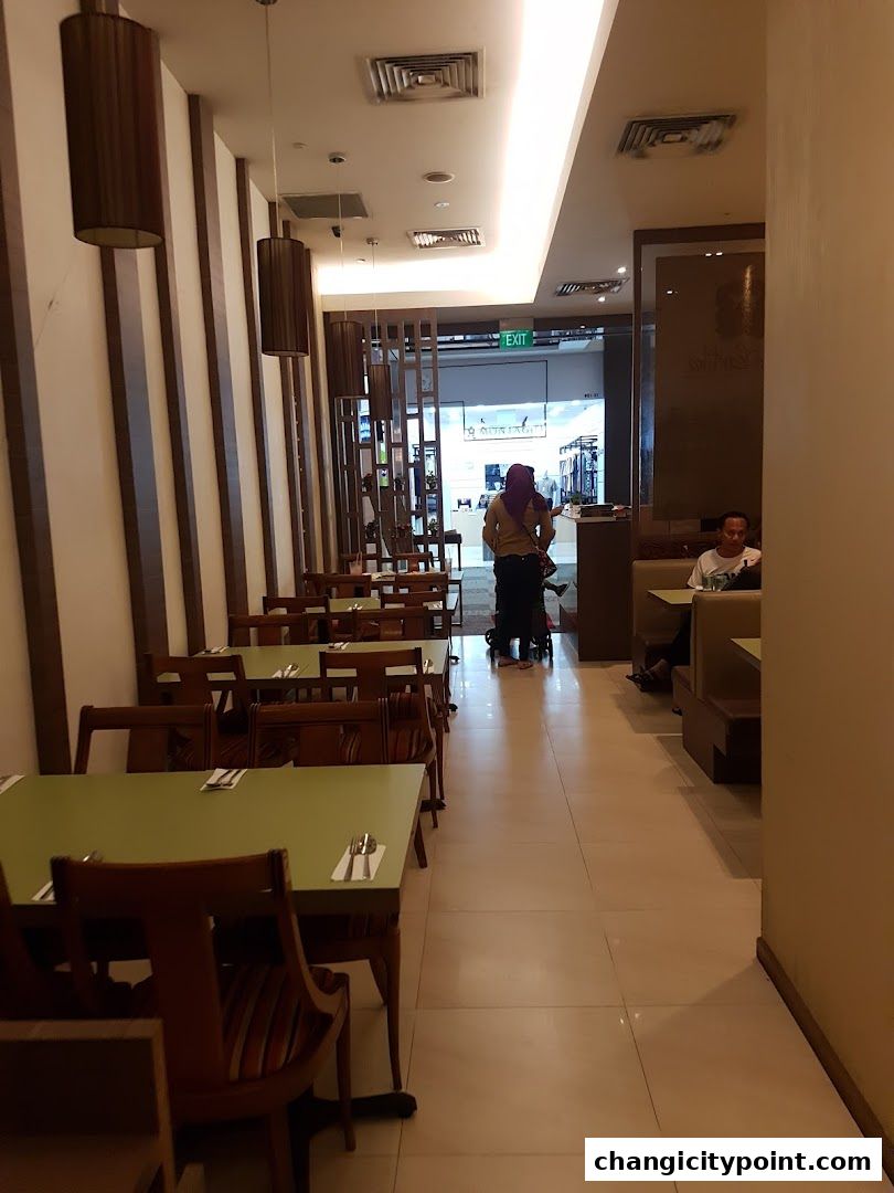 Interior view of Pondok Kartika restaurant with tables and chairs, and people in the background.