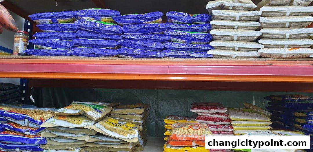 Shelves stocked with various packaged Indian groceries, including rice, flour, and other staples.