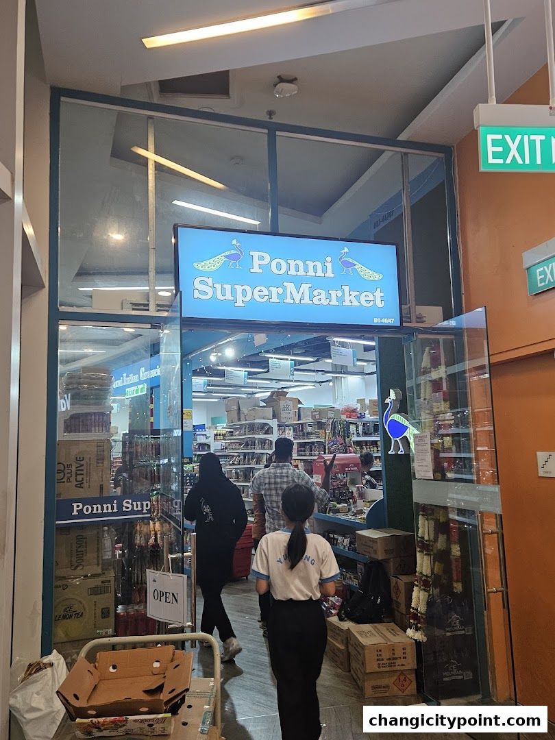 Entrance to Ponni SuperMarket, an Indian grocery store, with products visible inside.