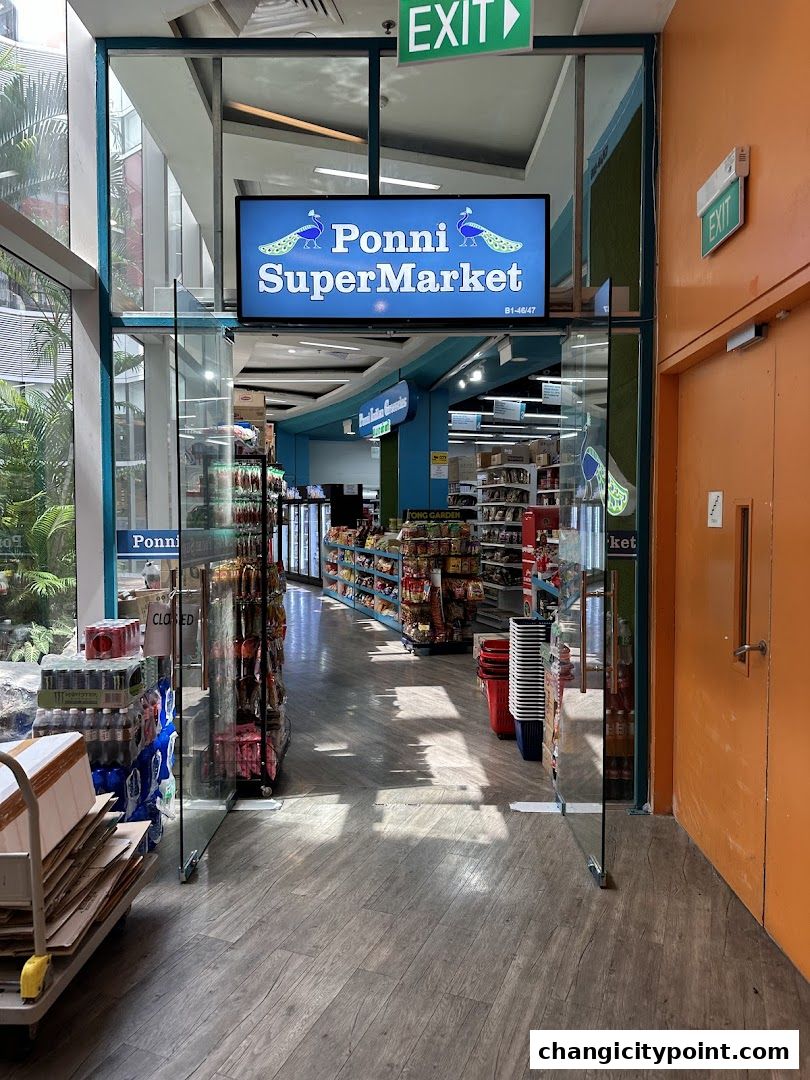 Entrance to Ponni SuperMarket with shelves stocked with groceries and a sign above the entrance.