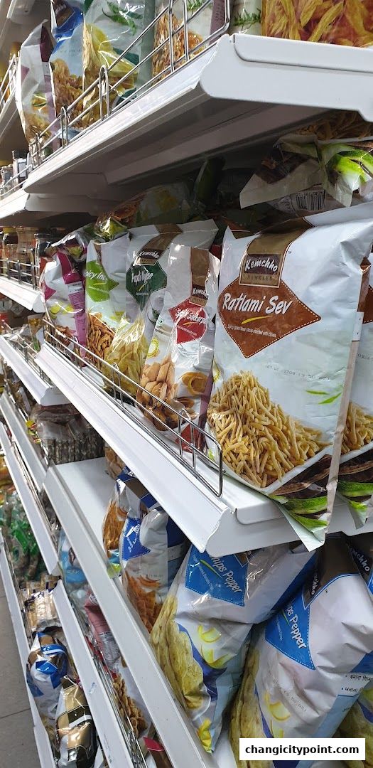 Shelves stocked with various packaged Indian snacks and namkeen.