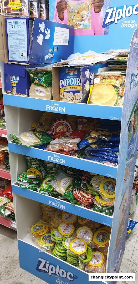 A display stand filled with various food items, including popcorn and packaged snacks, with Disney Frozen branding.
