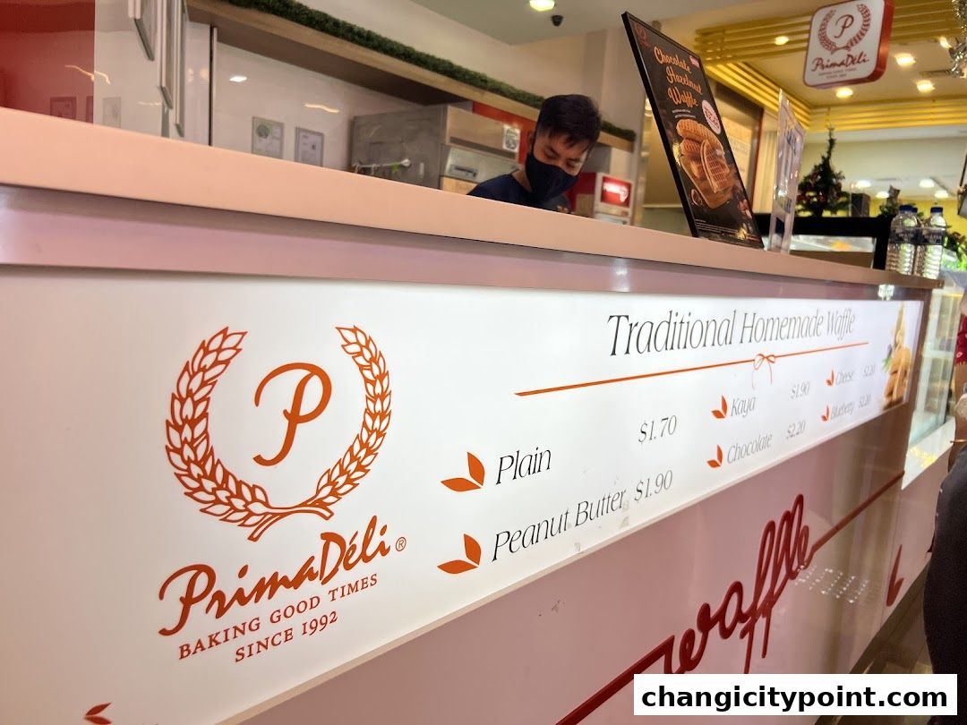 A counter displaying traditional homemade waffles with various flavors and prices.