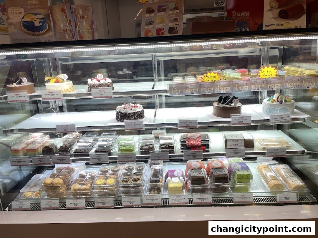 A display case filled with various cakes, pastries, and desserts from PrimaDéli.