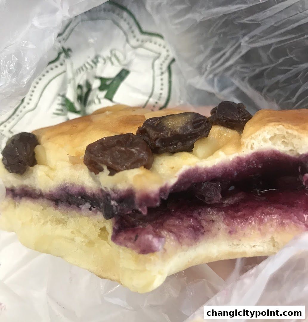 A close-up of a delicious pastry filled with blueberries and raisins from Proofer Boulangerie.