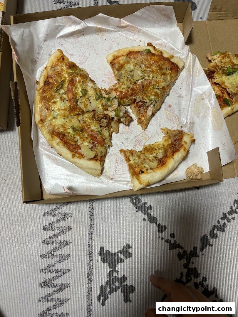 A close-up of a pizza in a box, with several slices visible.