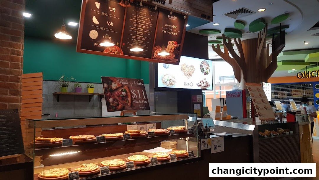 A bakery display with pizzas and a menu board hanging above.