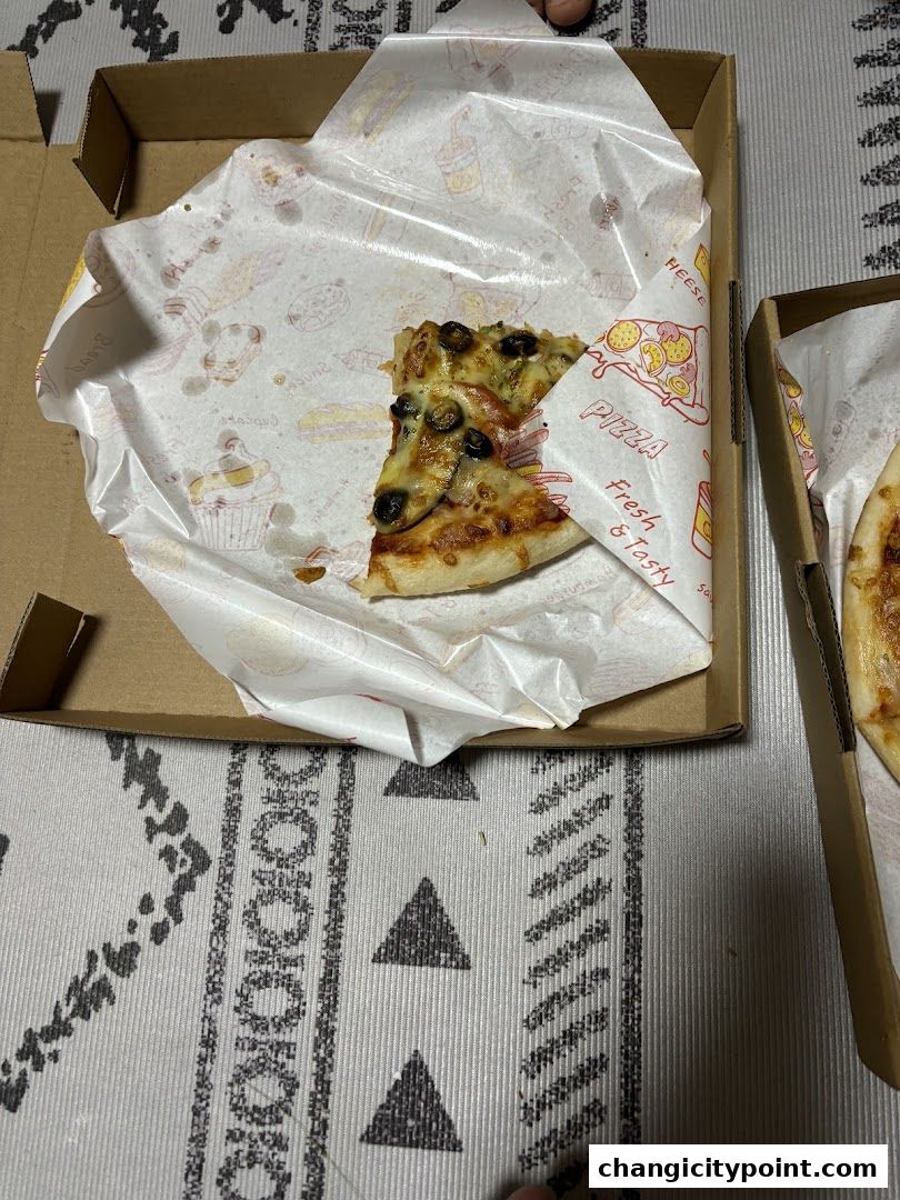 Two slices of pizza with olives and cheese in a pizza box.