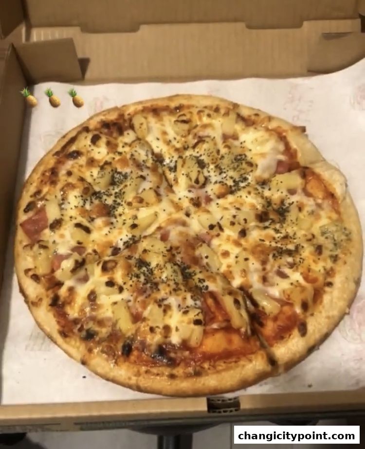 A delicious pizza with pineapple and ham, ready to be served.