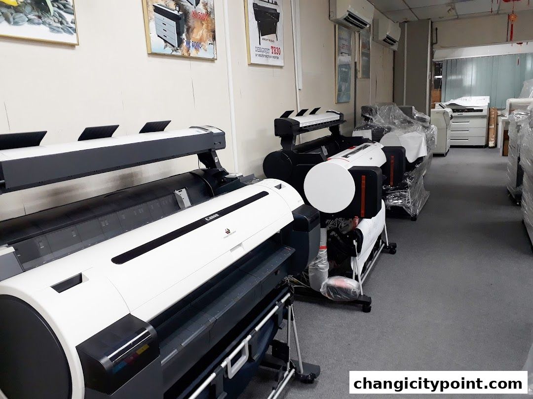 Interior view of a shop displaying large format printers and copiers for rent or lease.