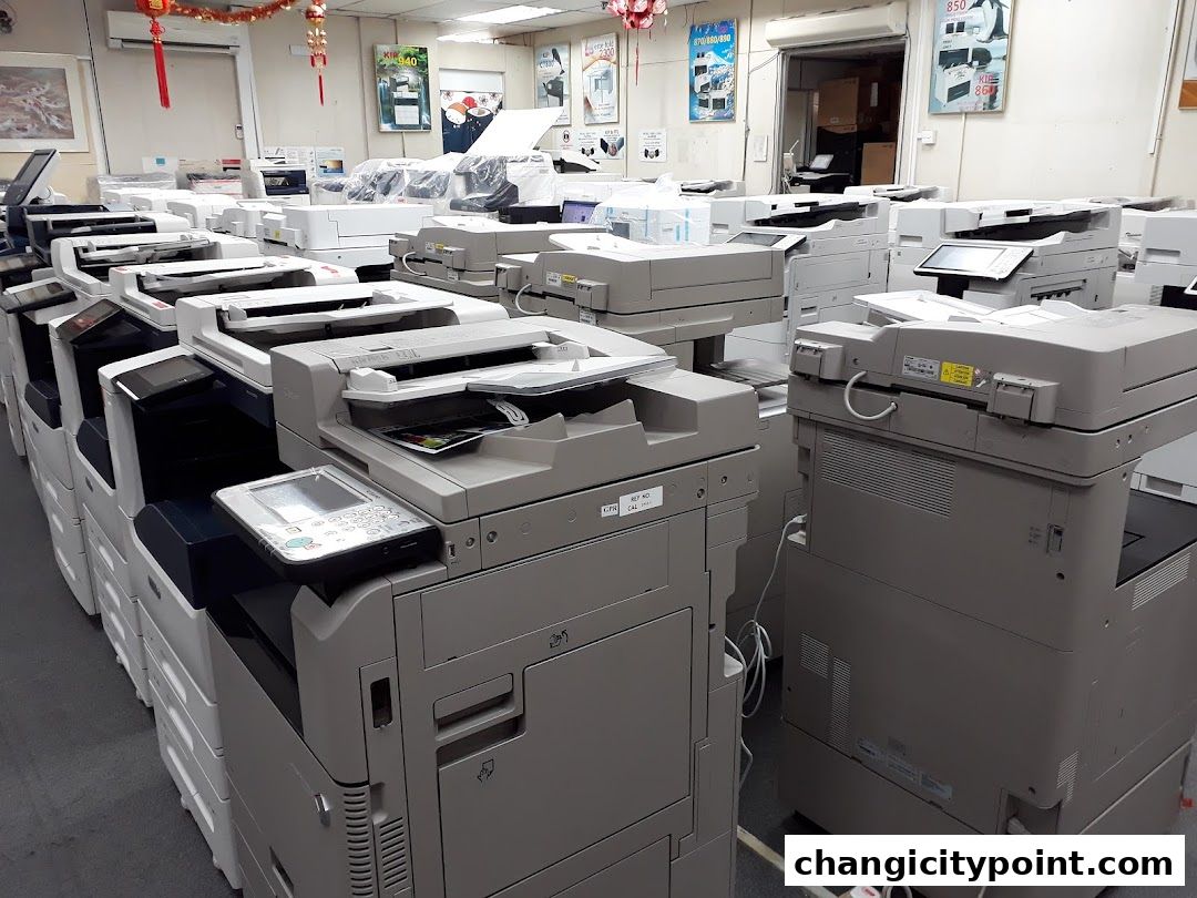 Rows of printers and copiers are displayed in a retail store.