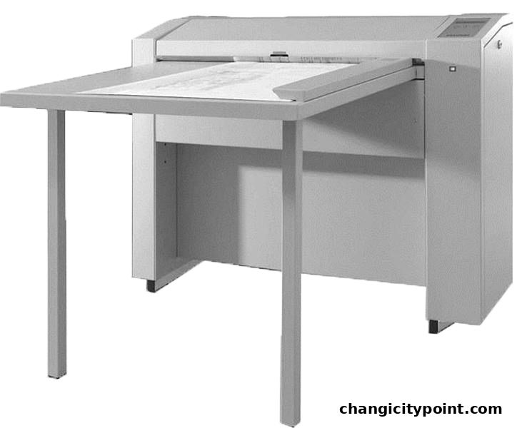 A large, gray copier or printer with an extended tray for paper.