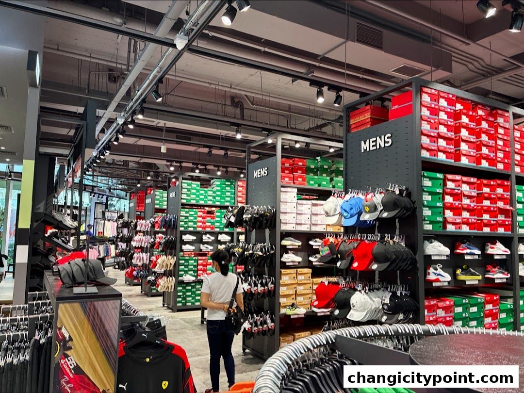 Interior view of a PUMA Outlet store with shelves of shoe boxes and apparel.